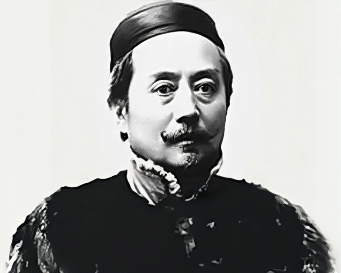 1871年德国火车上，辜鸿铭手拿报纸，倒着在看。两名德国小伙在一旁用德文嘲讽：“