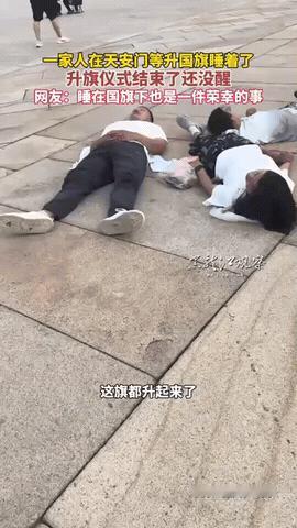 一家人前往天安门排队等看升国旗，不料正在进行升旗仪式时，一家人却直接躺广场上睡着