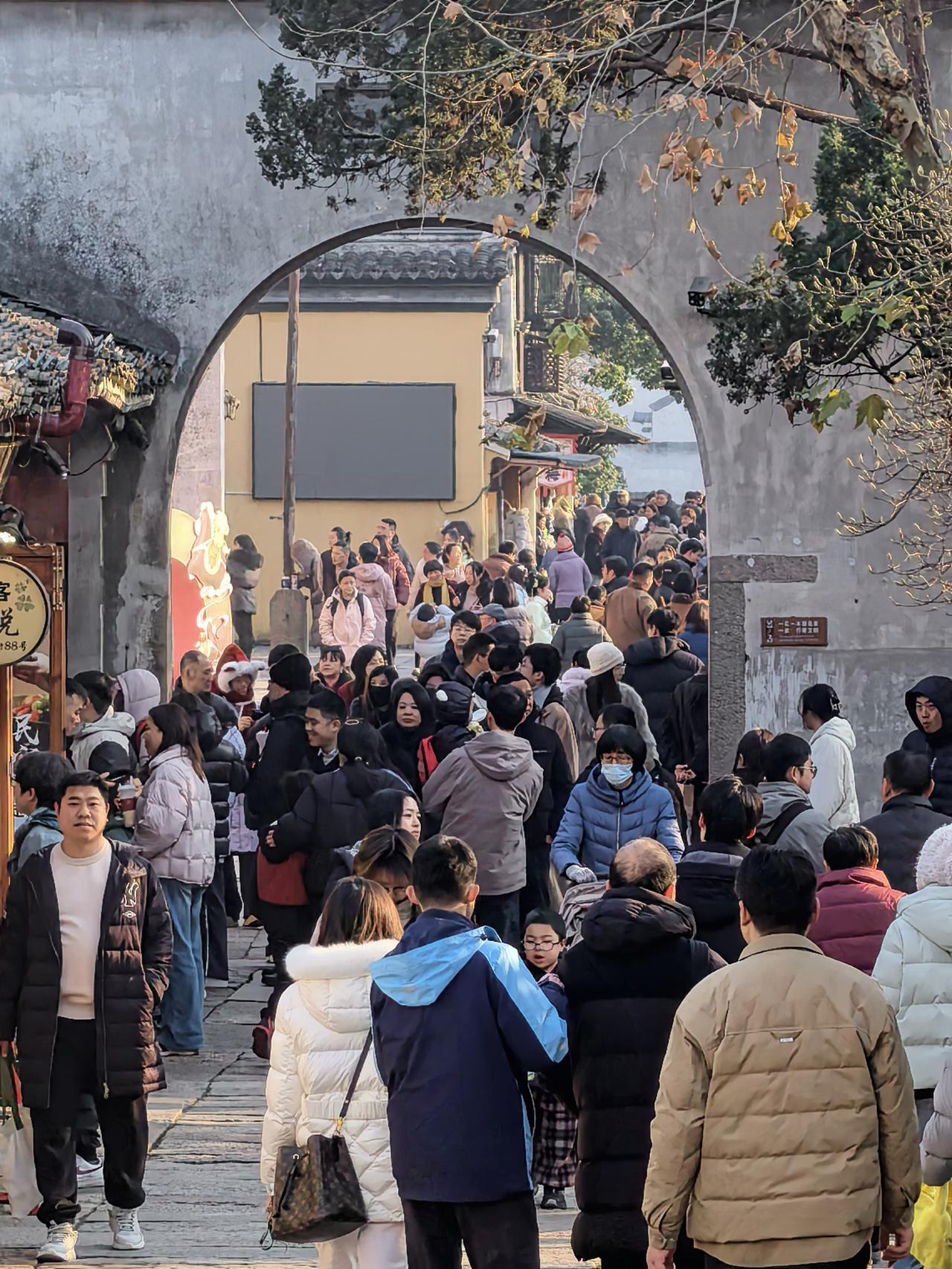 元旦期间旅游市场一片火热。浙江湖州南浔古镇，青石巷陌间人头攒动，摩肩接踵的游客们