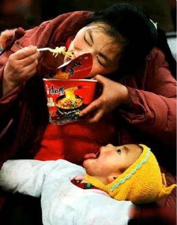 这张照片拍摄于2004年1月18日，春运高峰期间，北京西站的候车室里，一位母亲用