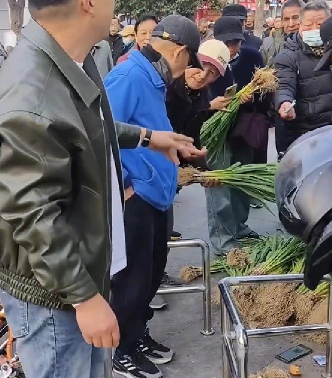近日，安徽。男子在街头叫卖蒜苗一块钱一把，称是自己老娘种的，在家里卖不掉，都愁死