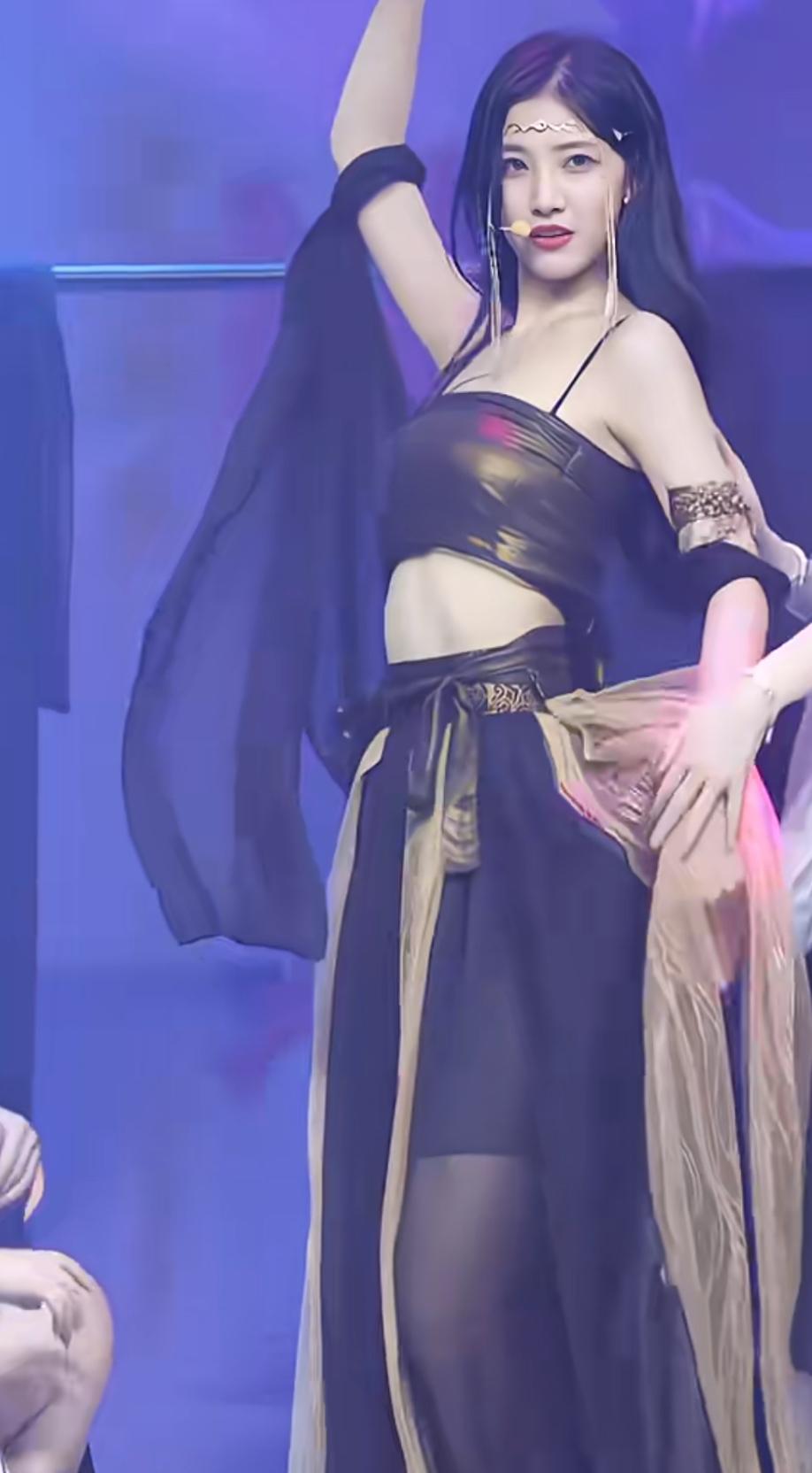 舞台灯光揉碎在裙摆的金纹里，袖间纱幔随动作轻晃，她抬手的瞬间，像把夜色裁成了摇曳