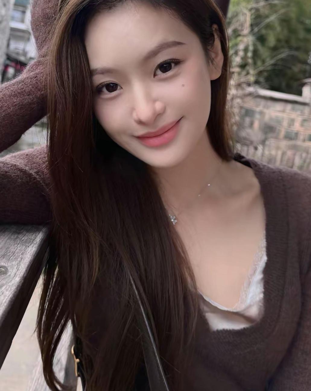 薄暮时分，她独自来到河边，微风轻拂，带起她额前几缕发丝，似在为她梳理这片刻的宁静