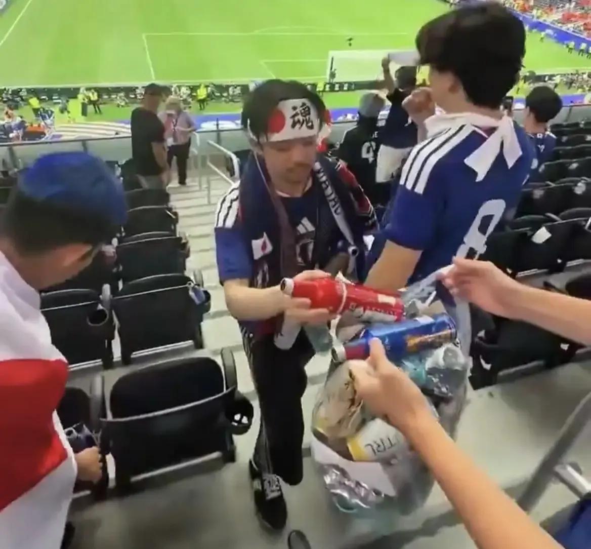 日本人又开始捡垃圾了，还带着专业摄影团队，既然要捡又何必丢呢世界杯看台上日本球