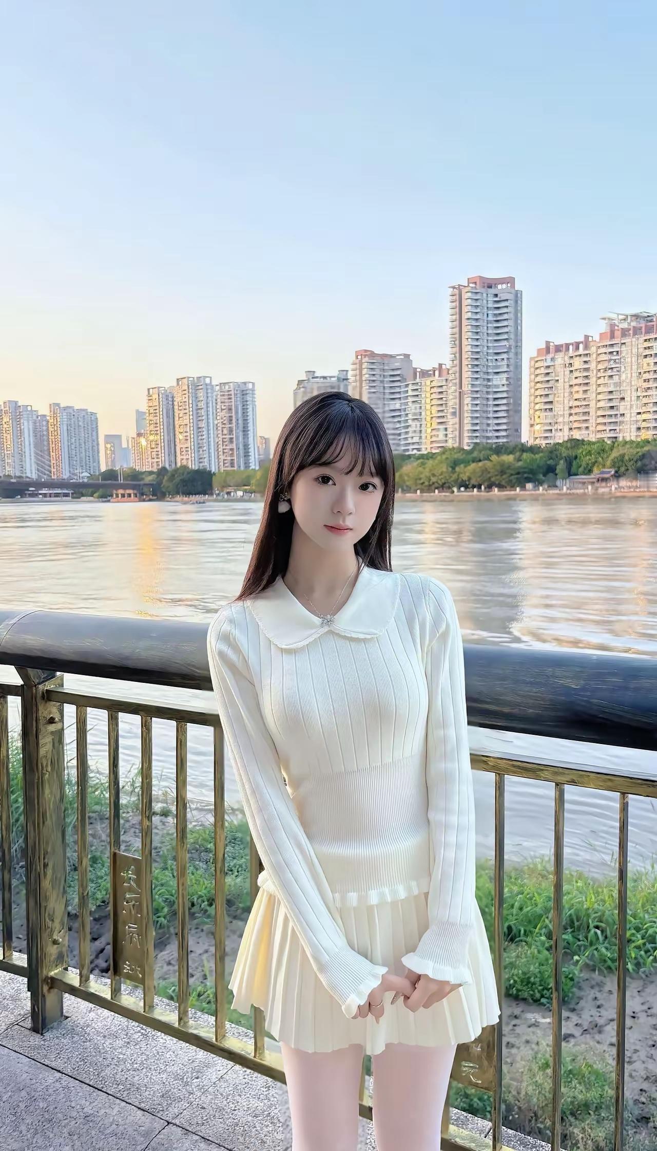 河畔少女，优雅白裙，城市天际线作背景，清新自然。