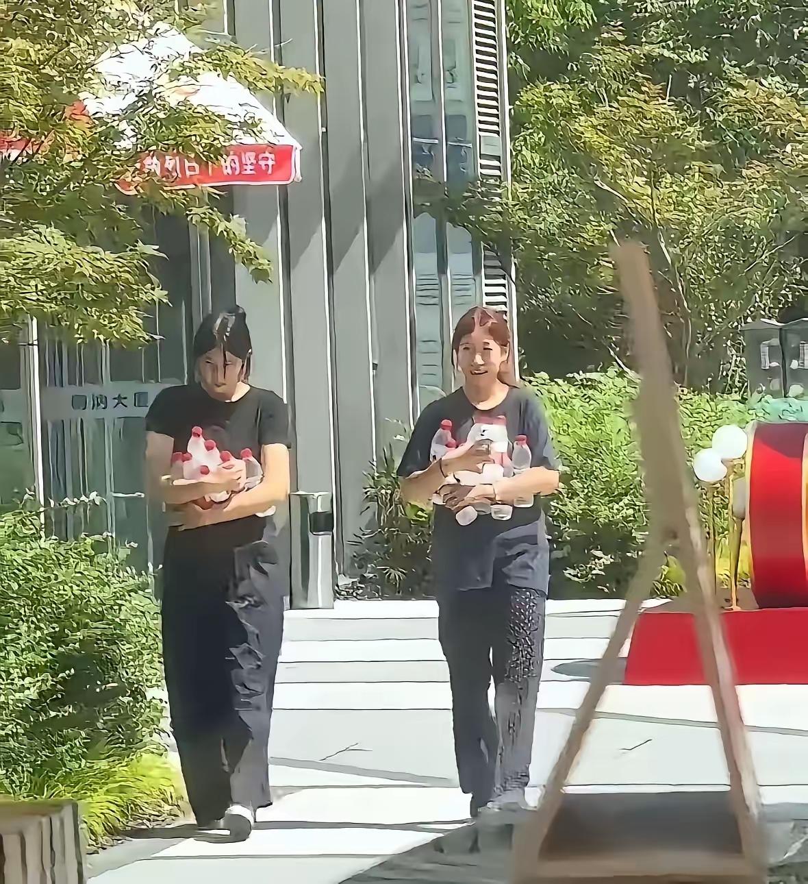 两个小姑娘，看着挺清秀，穿着统一的工服，估计是在附近打暑假工。她俩溜溜达达走到冰