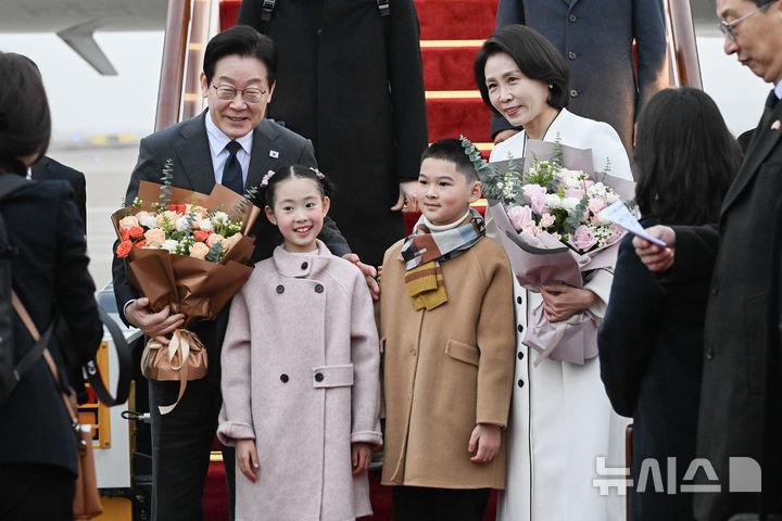 给李在明献花的两位小朋友，真好看！一个穿浅粉色大衣扎双丸子头，眉眼弯弯；一个驼色