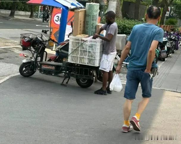 上海街头一黑人在做快递小哥？网图，他是不是真的是快递小哥，咱也不清楚。如果是