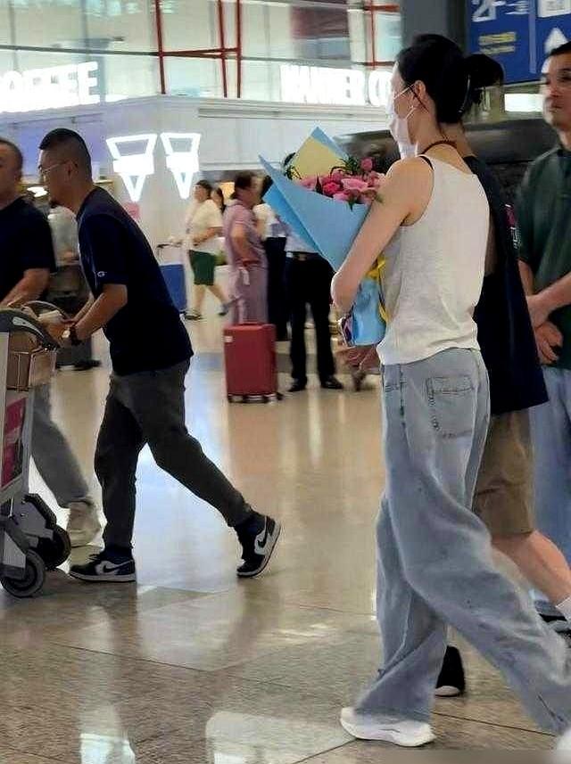 梁洛施一走下飞机，那个男人就把一束鲜花塞进她怀里，紧紧拥住她的肩膀。前一秒，