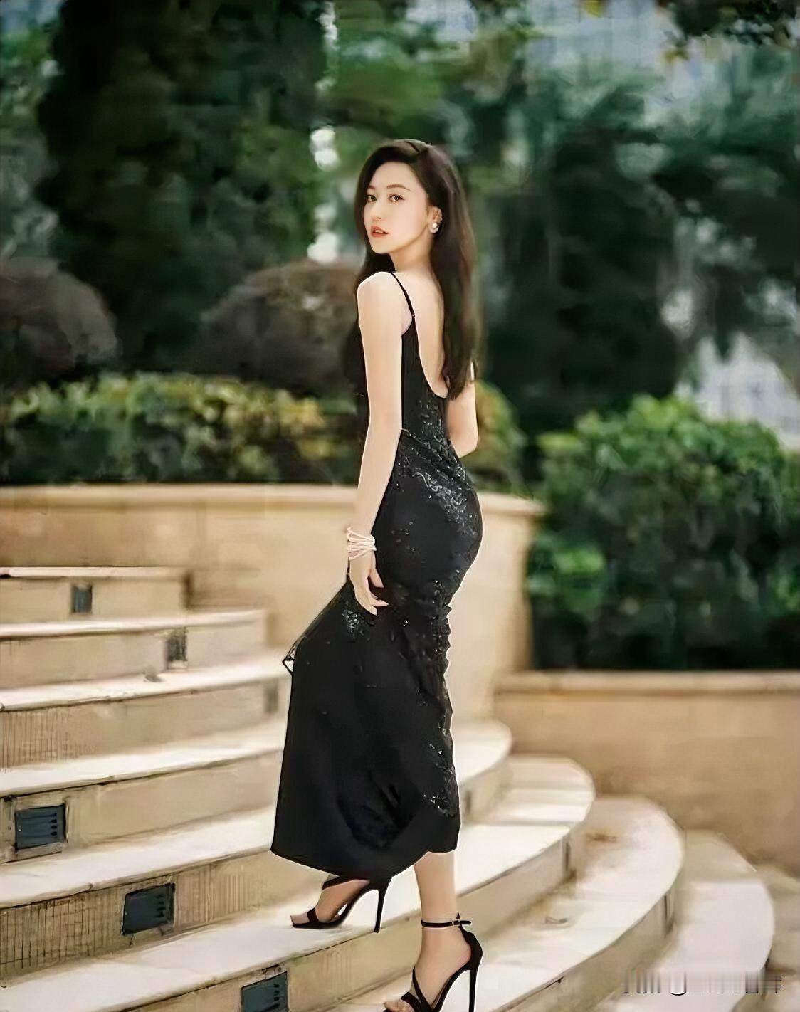 石阶蜿蜒，绿意轻拥。黑裙曳地，星芒暗涌。露背如弦，弹着晚风的歌。高跟叩响，