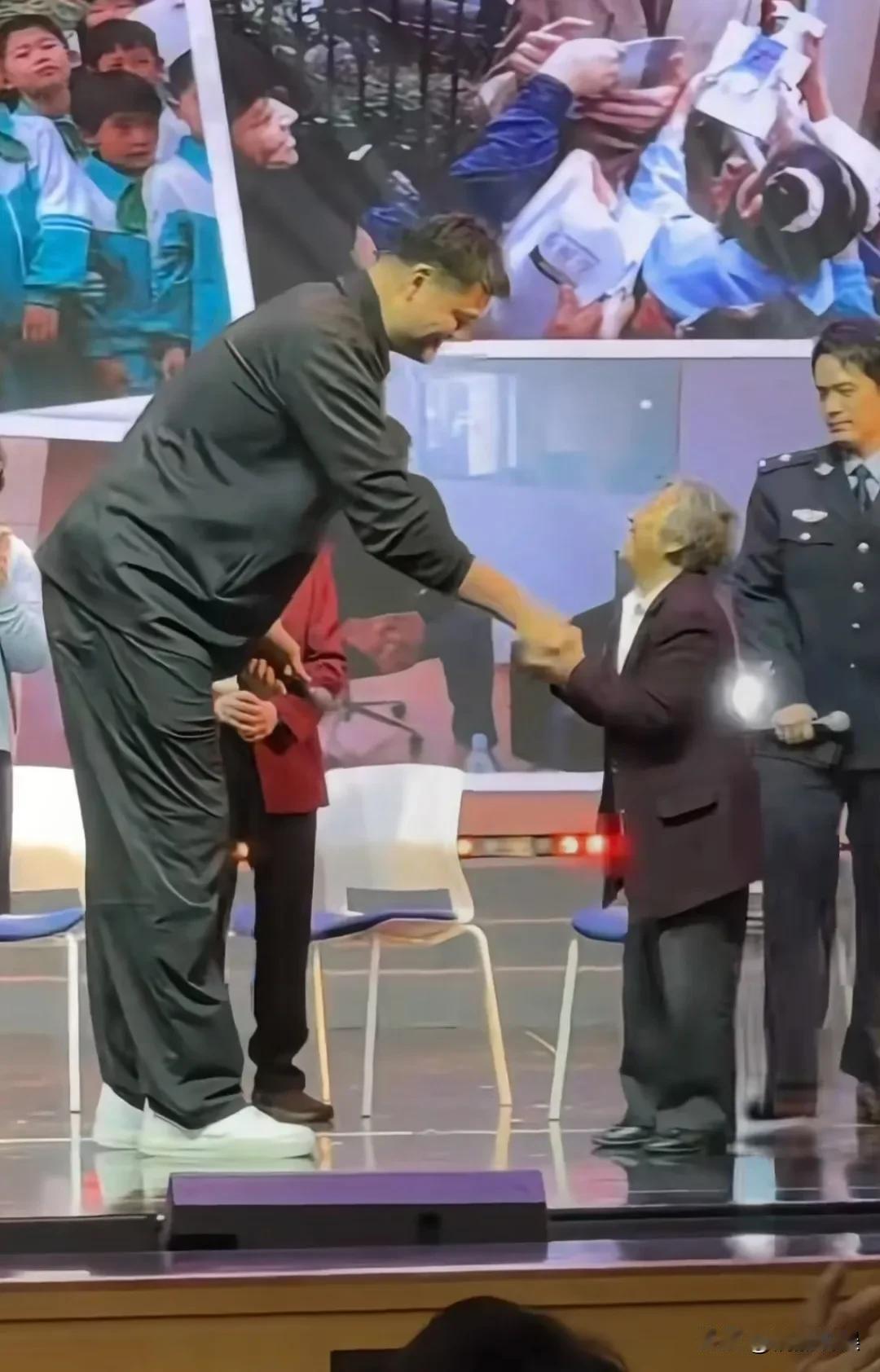 姚明从美国返回上海，现身小学母校，参加母校七十周年校庆。2米多高的姚明，和小小