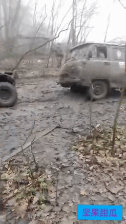 小车推军用卡车。乌克兰前线，乌东恶劣天气，俄军一辆卡车被陷在烂泥路，车轮开不出来
