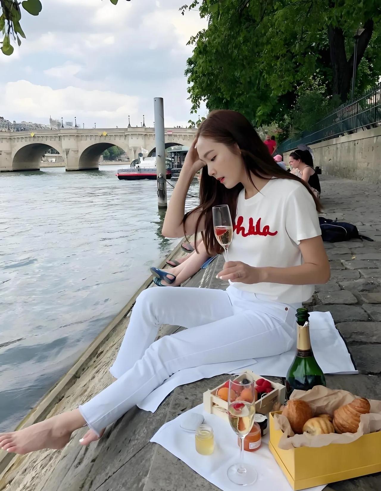 巴黎塞纳河畔，美女就地开始野餐，然后拍一张性感美照。确定河边没有异味吗？女神身