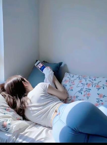〔欣赏图片〕图中画面挺奇怪；美女休闲床上躺；专心独自刷抖音；又要网购把衣