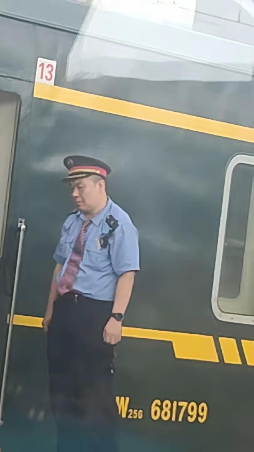 国庆假期出行拍到的这一幕，令不少网友心生感慨。一名五十多岁的铁路工作人员站在列车