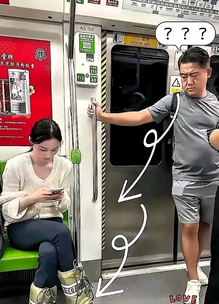 地铁里，她低头玩手机，他站得有点尴尬。