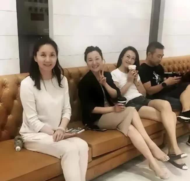 李修平穿着白色的套装，坐在沙发上，优雅端庄啊！笑容灿烂，气质杠杠滴！她主