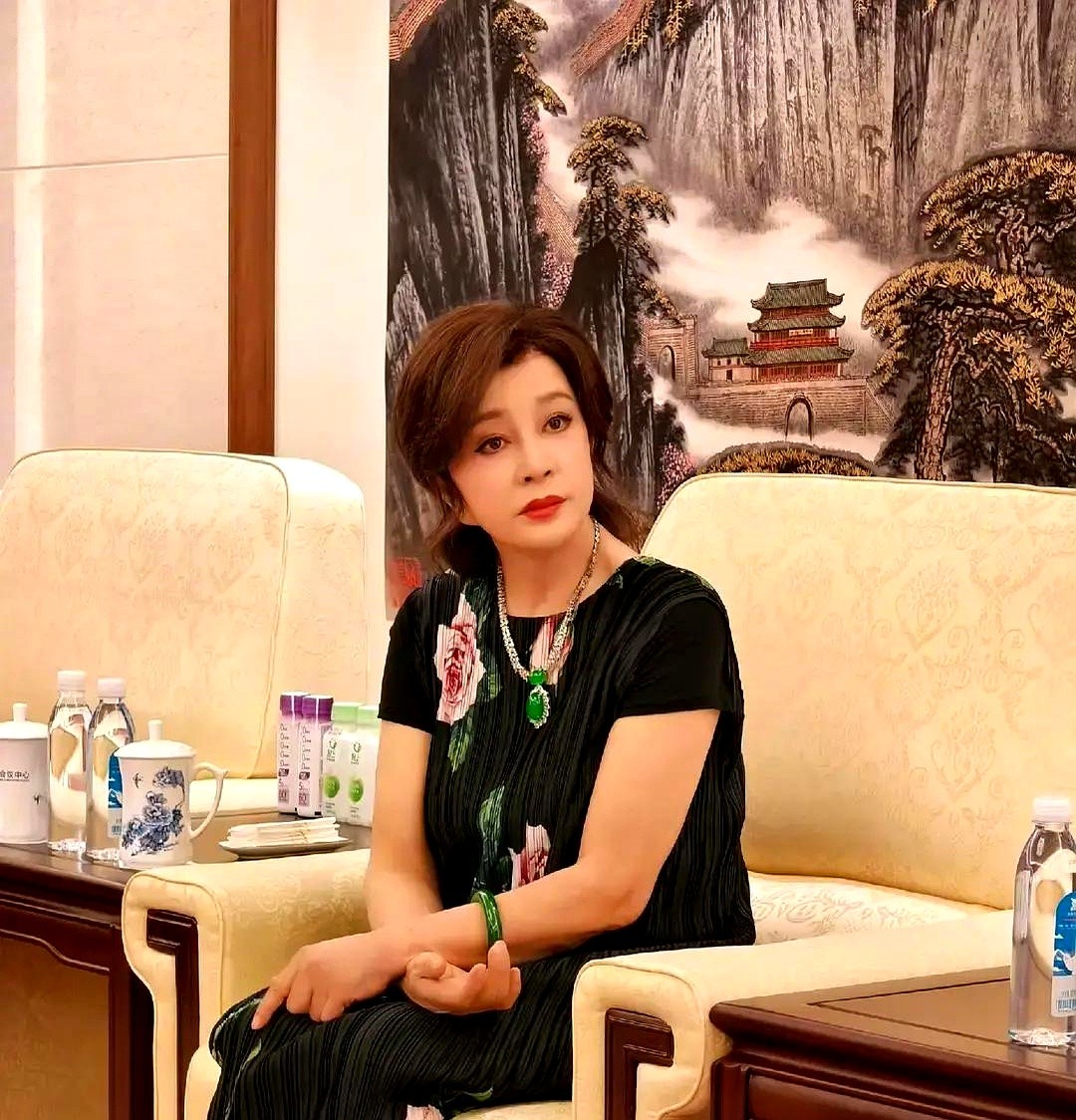 刘晓庆刚发了一组百花奖活动的照片，脖子上那块绿翡翠项链还是那么惹眼。黑底牡丹花纹的百褶长裙，手腕上套