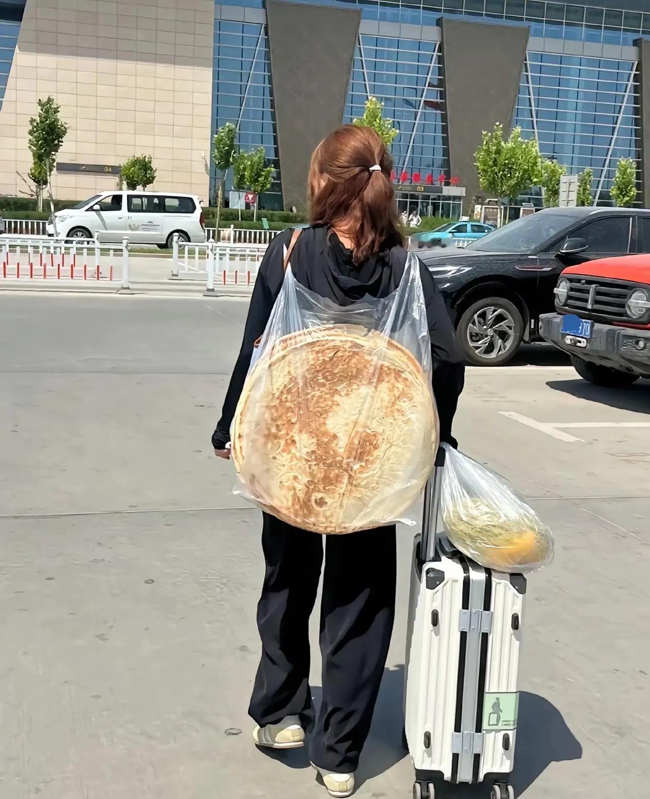 网友发的这张图片，我看了很久才发现这个女孩背了一张大饼，这大饼可真能吃吗？太大了