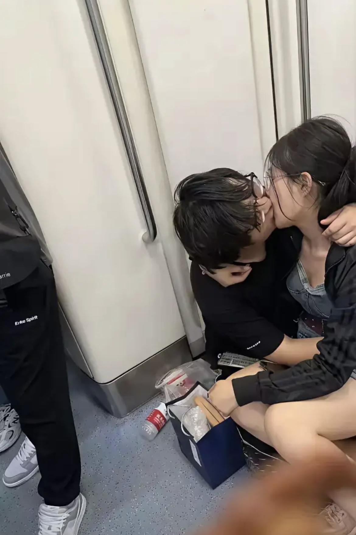 一对学生情侣在地铁上疯狂撒狗粮，周围乘客的反应各不相同。大爷一脸嫌弃，用报纸
