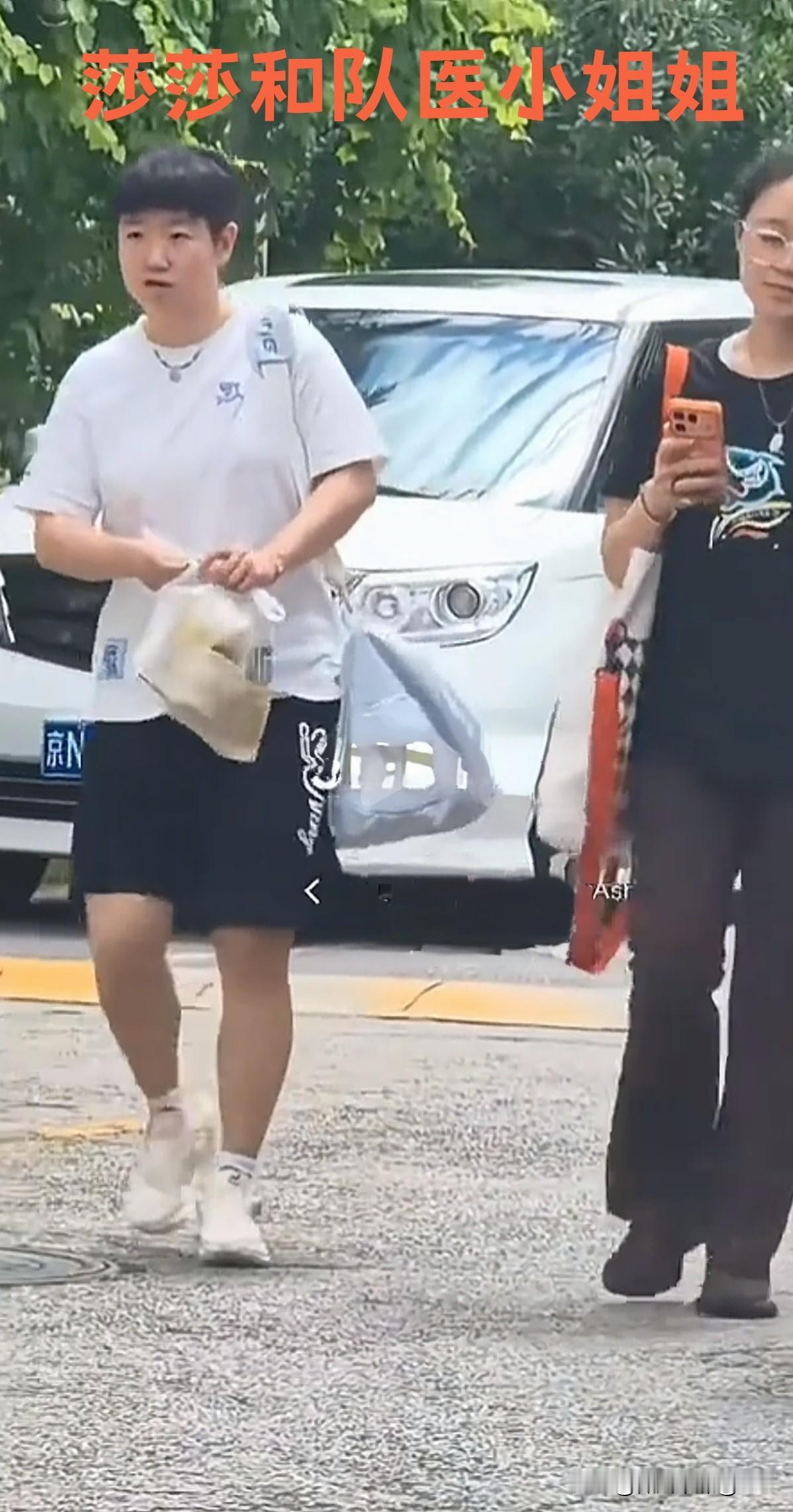 太逗了！偷拍莎莎的人被莎莎现场抓包了，哈哈哈！大热天，莎莎拎着一大袋喝的和队