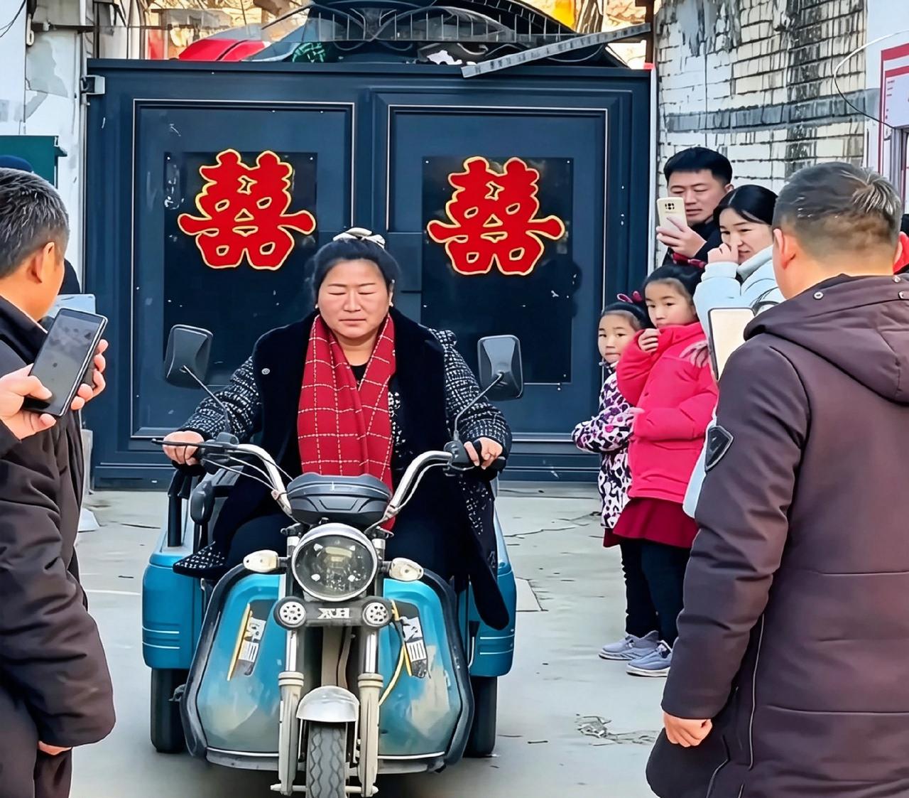 门口贴着双喜，大衣嫂骑三轮车出门，周围挤满拿手机拍摄的人。一举一动都被记录，这般