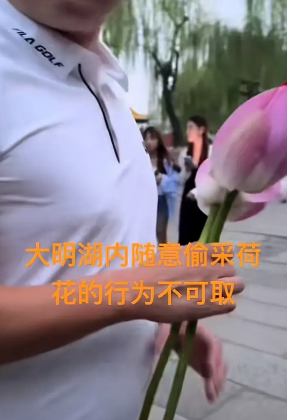 一名男子在游览大明湖时，发现湖中的荷花开的正艳，于是他跨过大明湖的石条护栏，来到