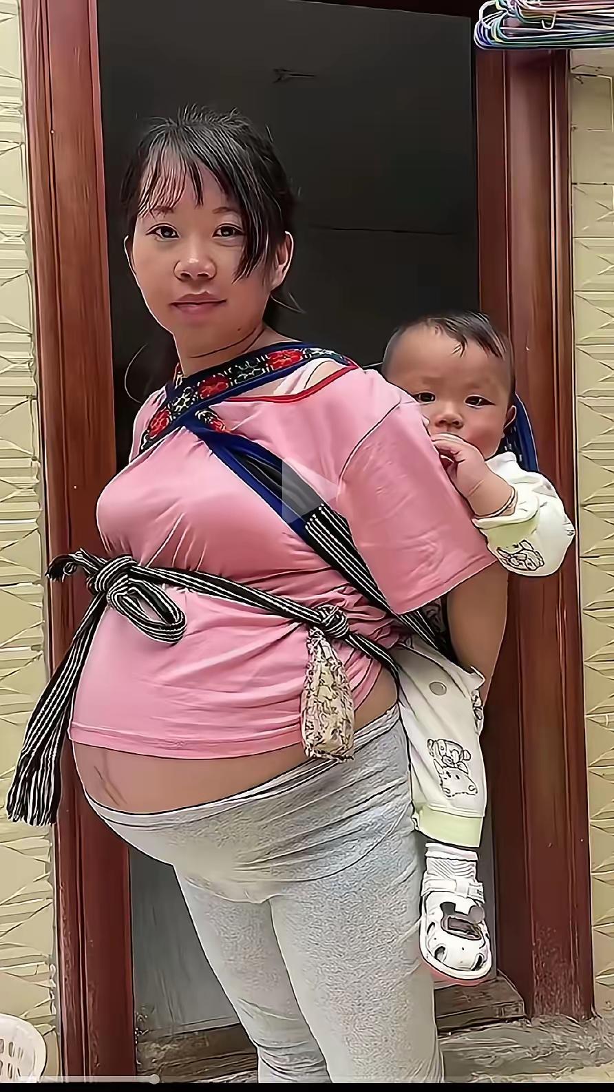 为的啥呢？背着的九个月，肚子里的六个月，丈夫在外打工，自己在家照看孩子，高兴的