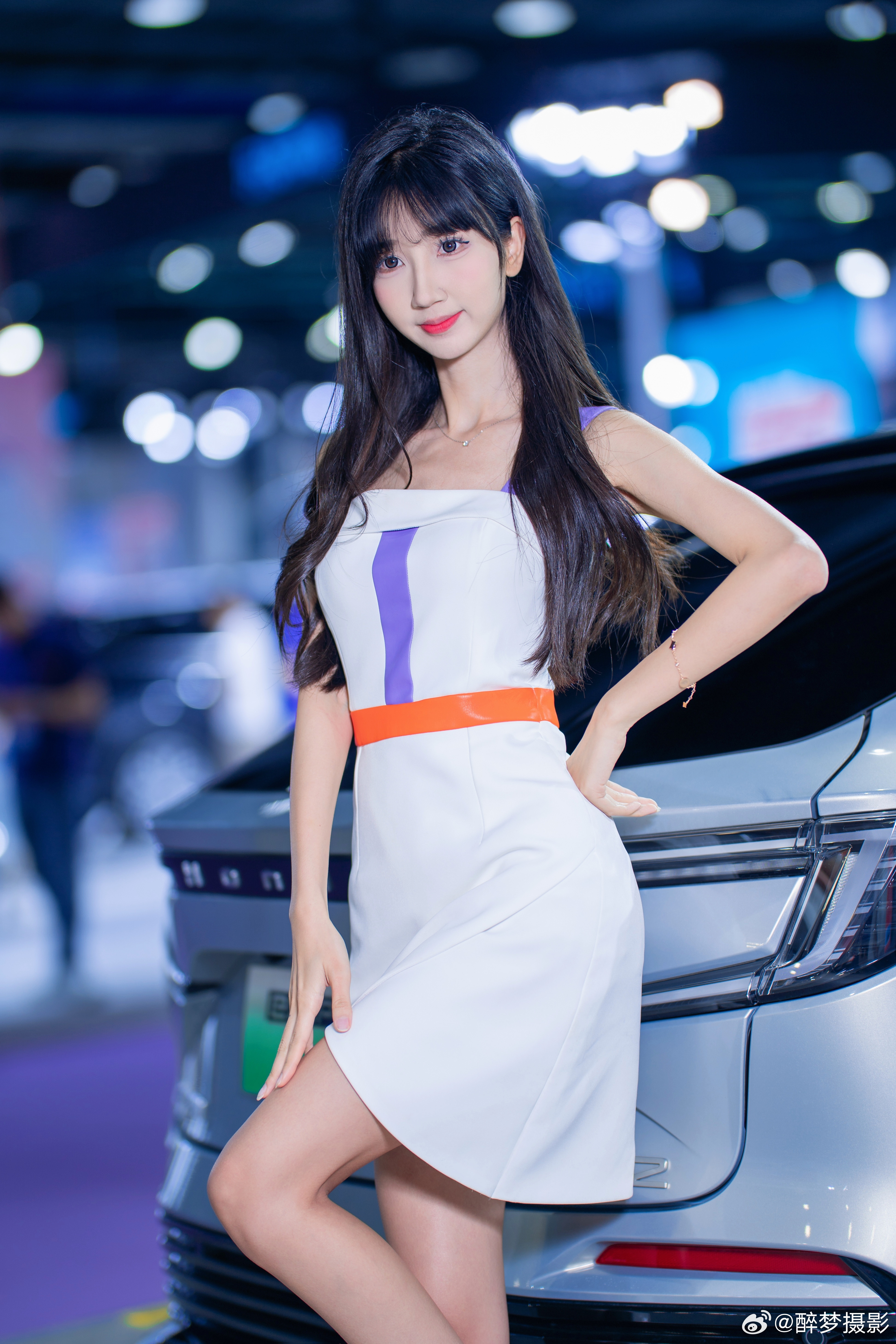 优雅与科技的邂逅✨白色礼裙搭配橙紫撞色腰带，尽显灵动气质～身旁的NP2车