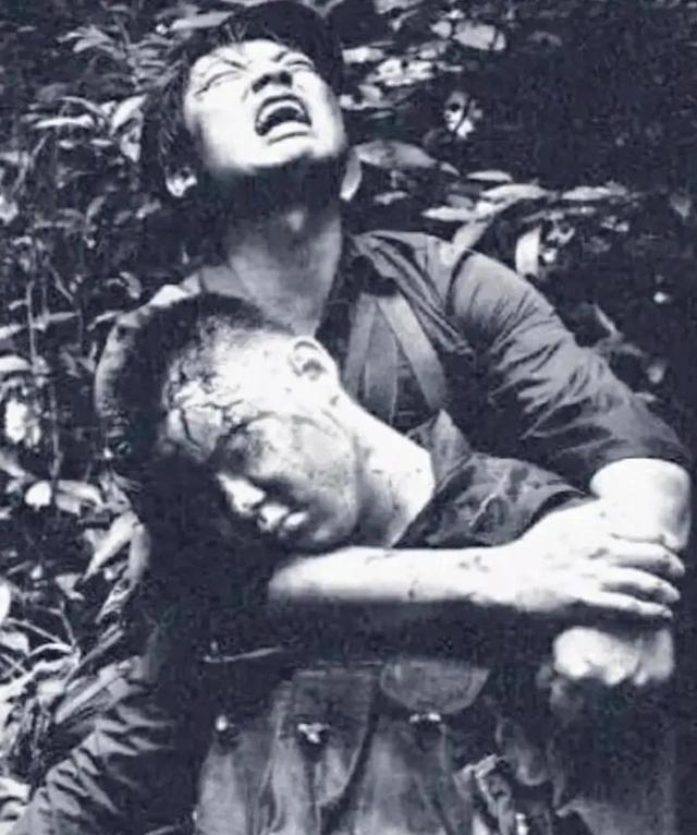 1984年，对越自卫反击战的211高地上，一名士兵头部中弹牺牲，他的战友抱着他的