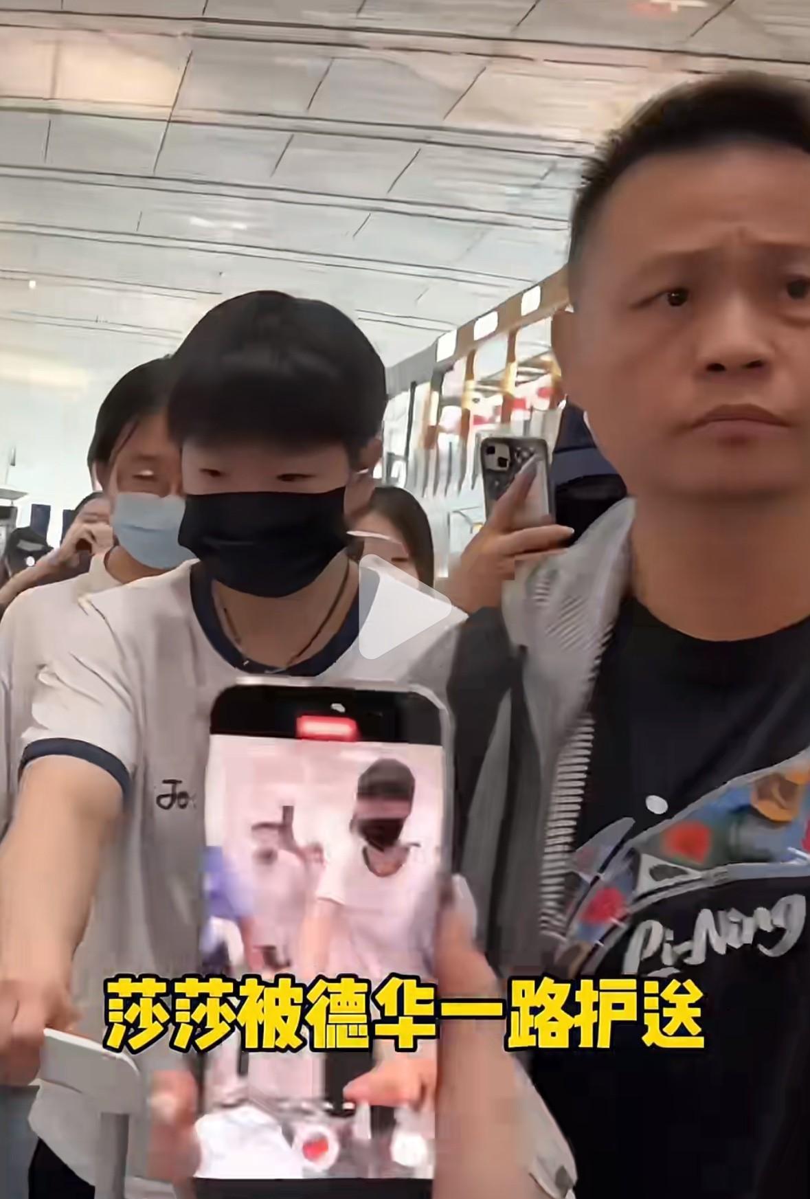 莎莎在机场被“球迷”团团包围，各种怼脸拍，莎莎推着行李箱已经没法前行了，看到德华