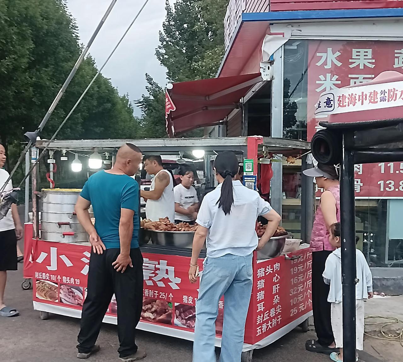 太卷了！卖个卤肉竞争相当激烈啊。两家熟食店紧挨着，左边那家老板吆喝，先尝后买，猪