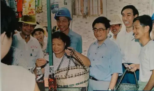 1994年7月28日，黄菊在高架路工地的便民菜场调研，可以看到有人戴着工地的安全