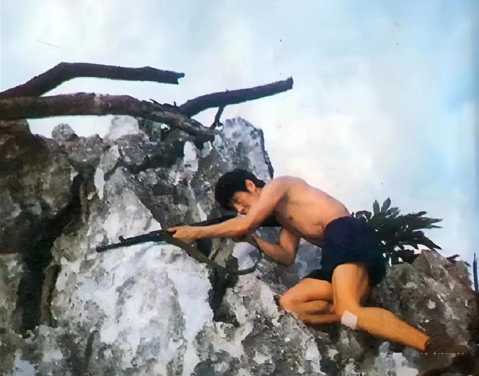 80年代的中越边境上，一位解放军战士坚守在一个岩石上。照片中这位解放军战士叫
