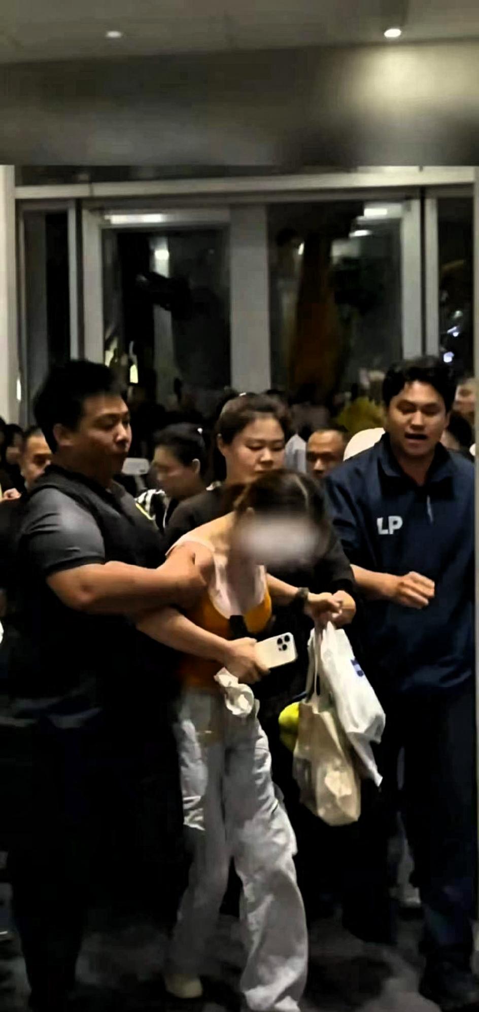 光天化日之下，一个中国姑娘被一群泰国工作人员锁喉抱摔，手链都扯断了，旁边的泰国粉