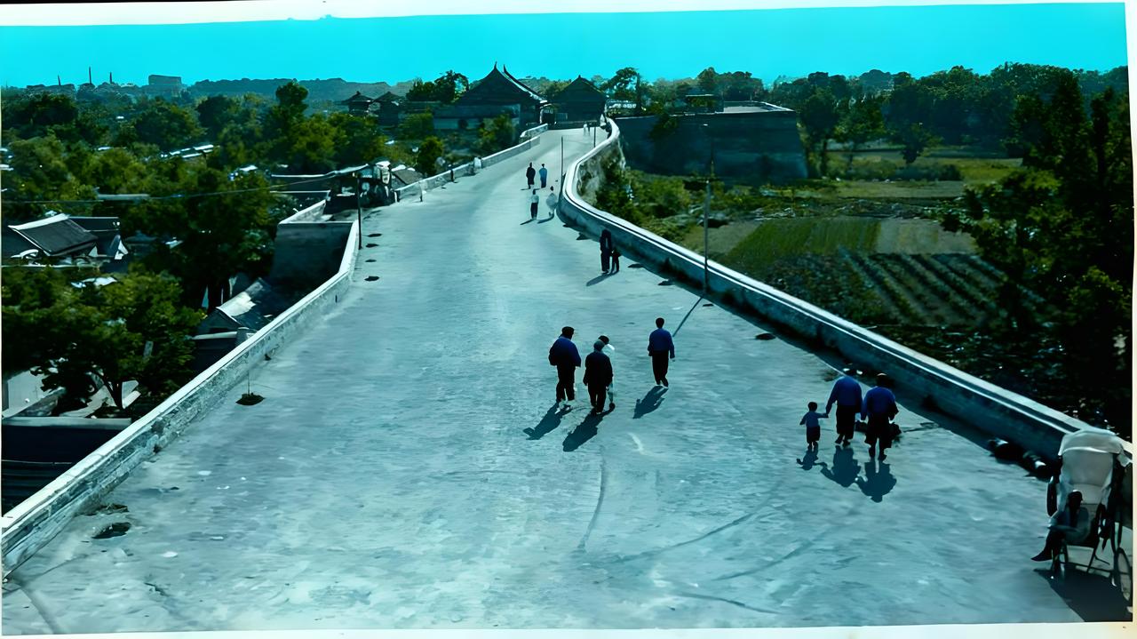 这张老照片定格了1930年代济南城墙改建后的休闲步道景象，宽阔的城墙顶面被砖石铺