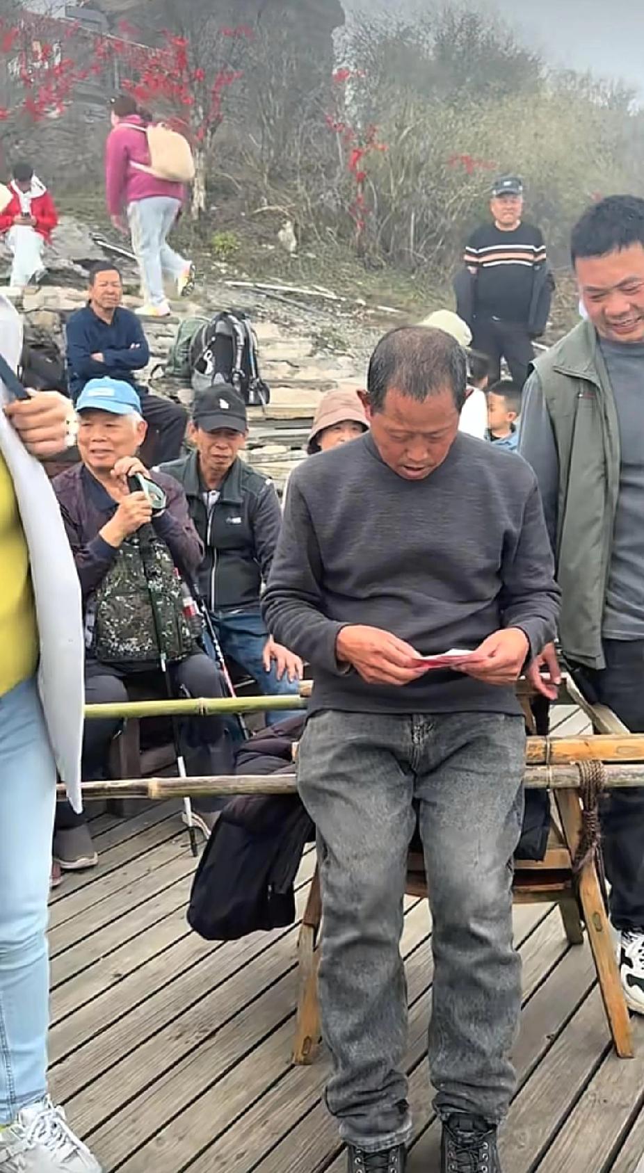 梵净山风景旅游景点，两名抬轿的轿夫，坐在路边，看着从眼前不断走过的游客，眼神里充