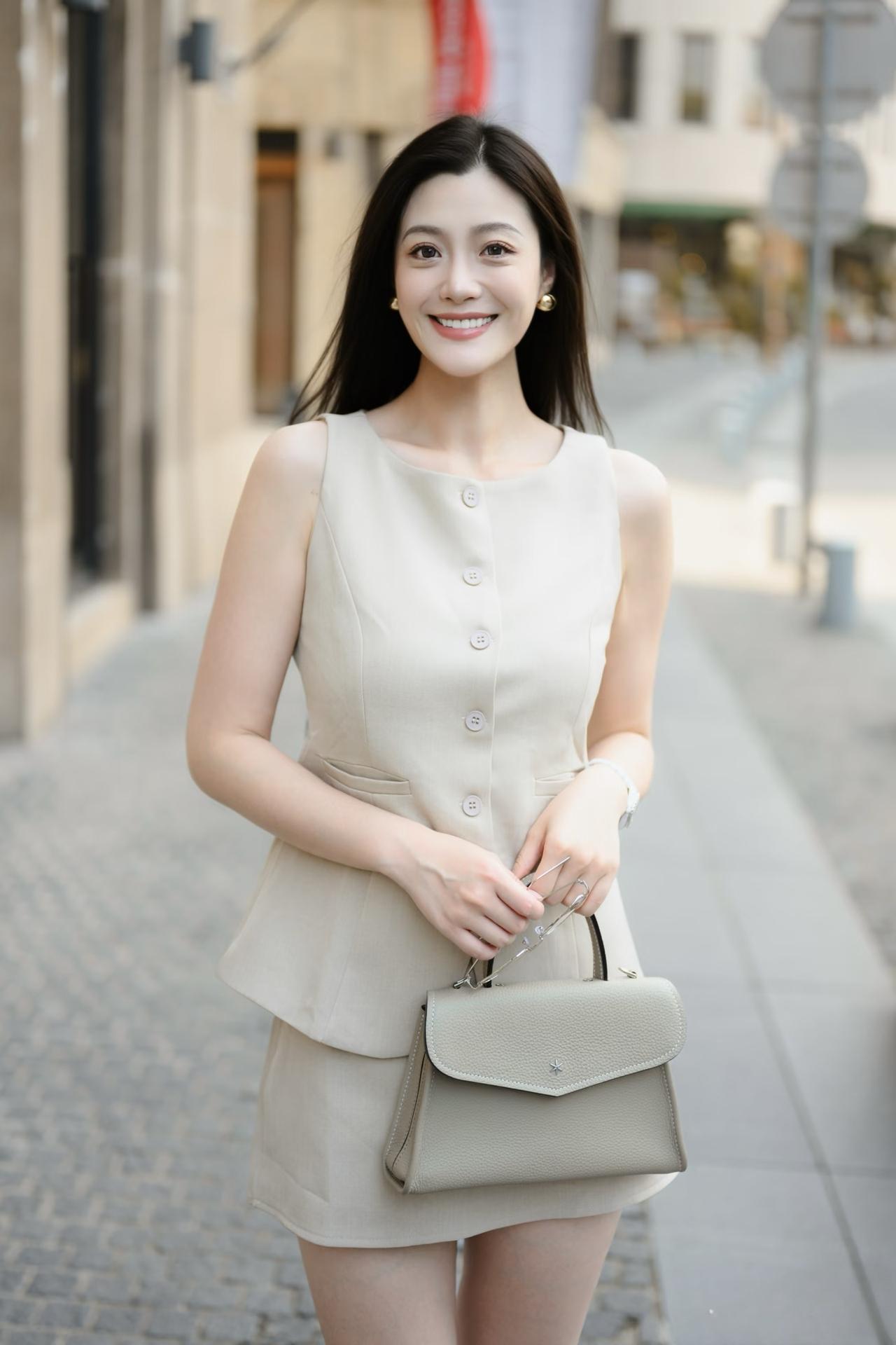什么样的穿搭可以成为气质女神?米色的马甲短裙套装，黑色的高跟凉鞋，令美女身材显得
