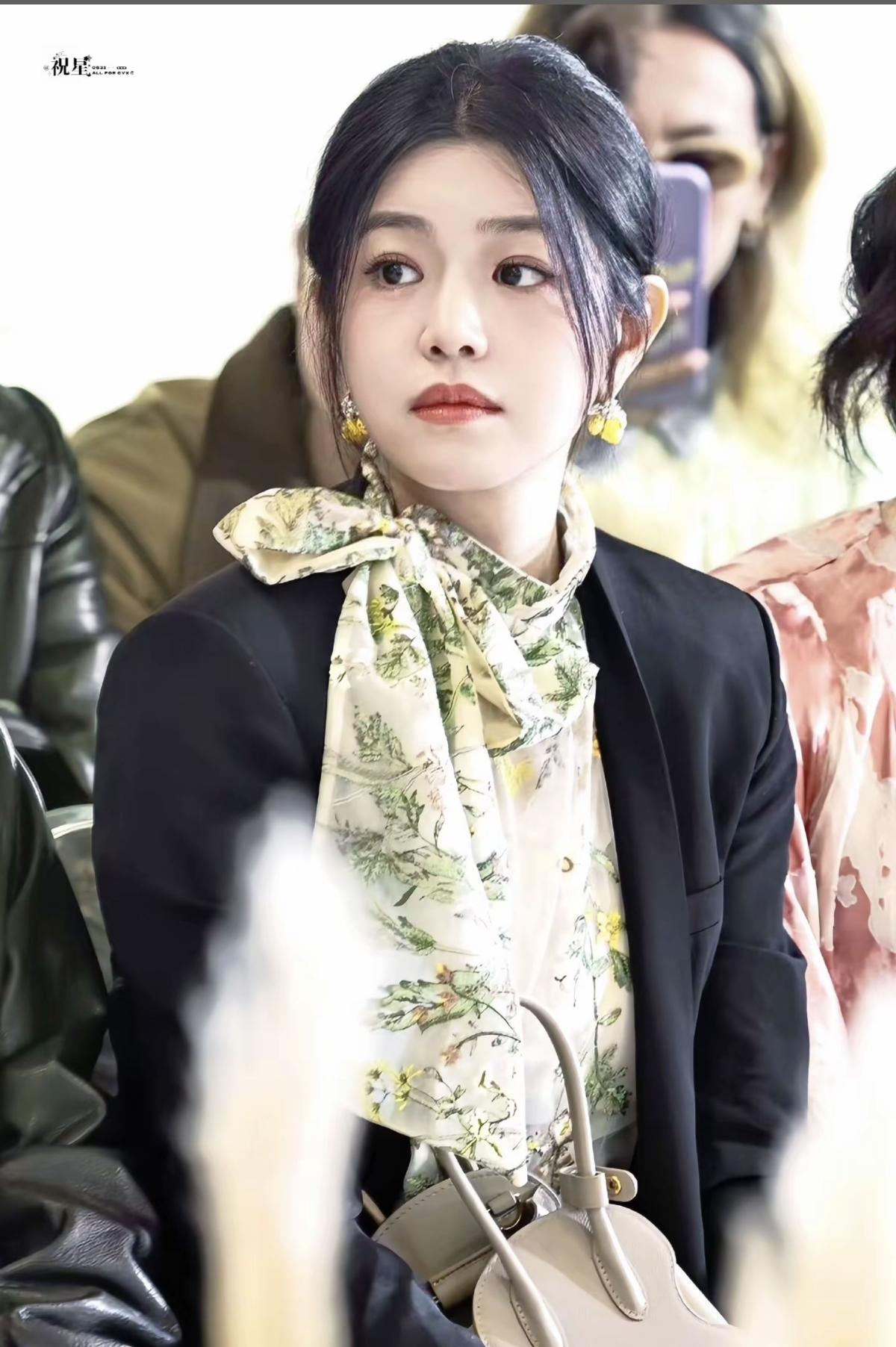 当秀场的喧嚣褪去，陈妍希静坐在人群中，植物印花与丝巾的绿意，是她与春日的温柔对话