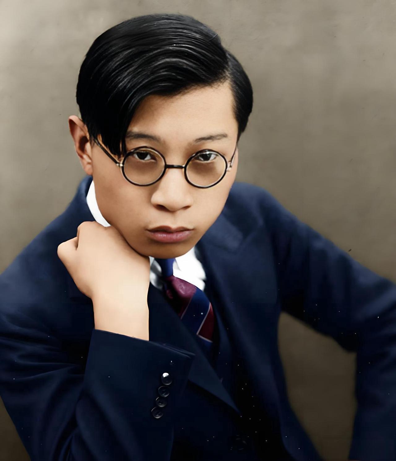 这是青年时期的傅雷的肖像照，当时他正处于留学法国前后的阶段，西装、圆框眼镜的装扮