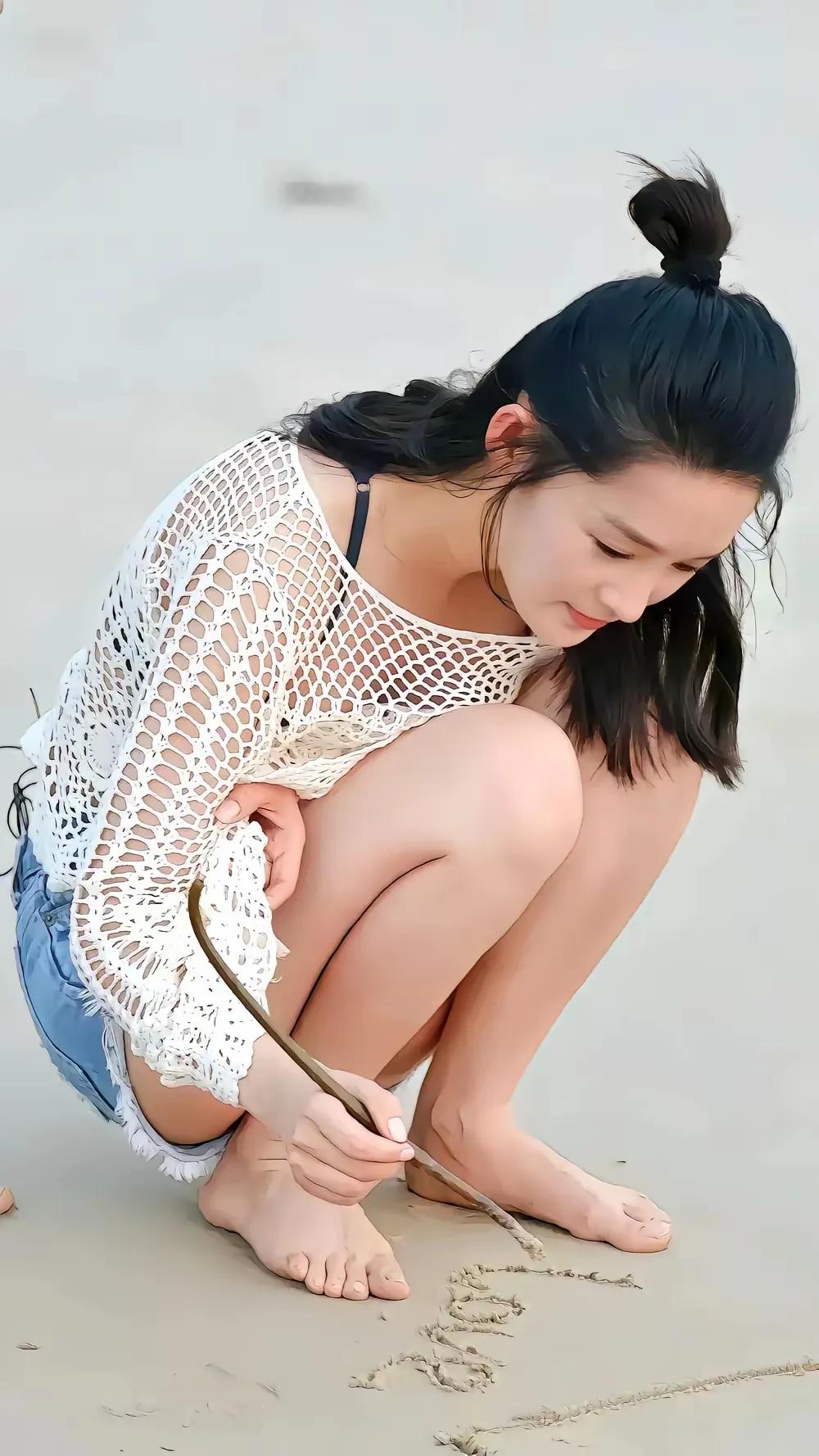 网上流出一组李沁在海边沙滩的抓拍镜头。她上身穿着蕾丝款上衣，下身搭配牛仔短裤，一身打扮清爽，特别契合