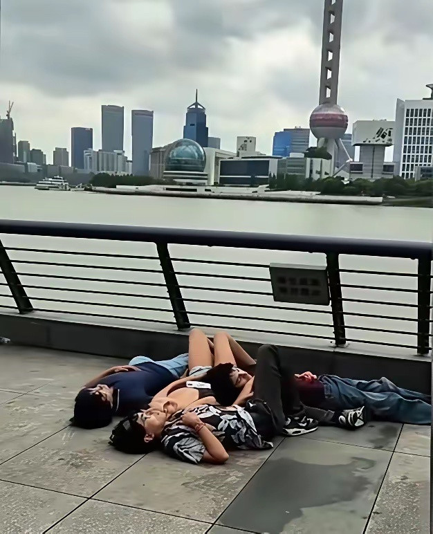 印度游客在上海外滩随地躺着吹江风，看着都很轻松惬意嘛。