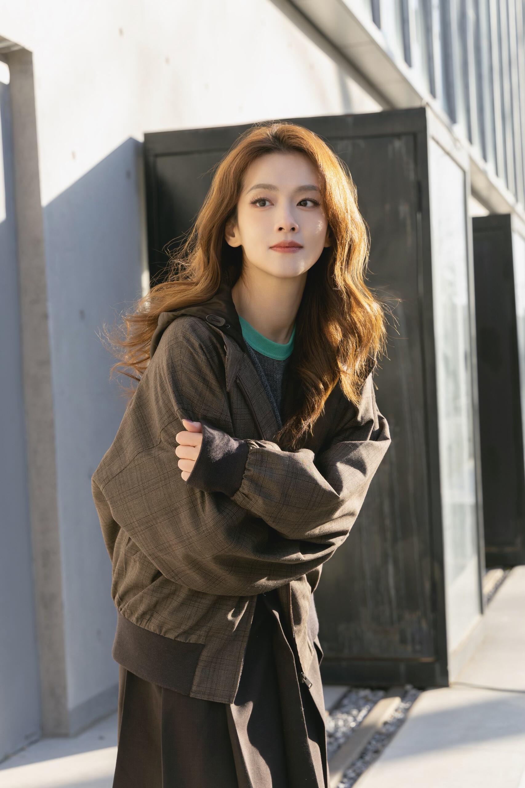 陈昊宇今日份温暖营业大片，身着PRADA格纹连帽外套搭配针织衫、半裙、尼龙背包和