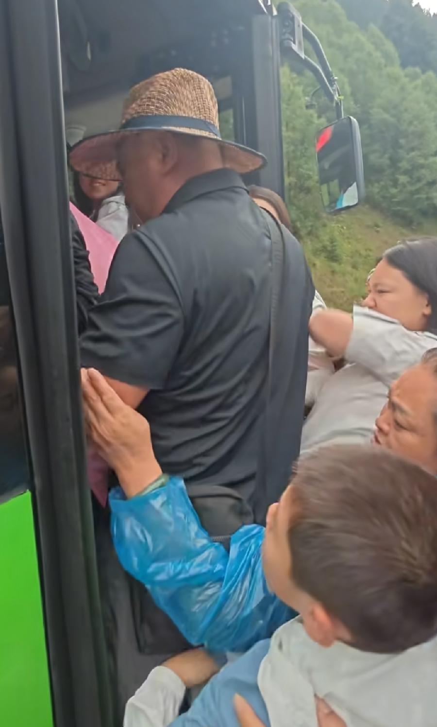 九寨沟人挤人挤公交，也不怕热了，一个小朋友女生挤不上去，在人堆里龇牙咧嘴，还是干