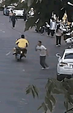 “救救我！”一白衣男子横穿马路，冲向马路对面的特警，对着特巡警指了指自己的脖子，