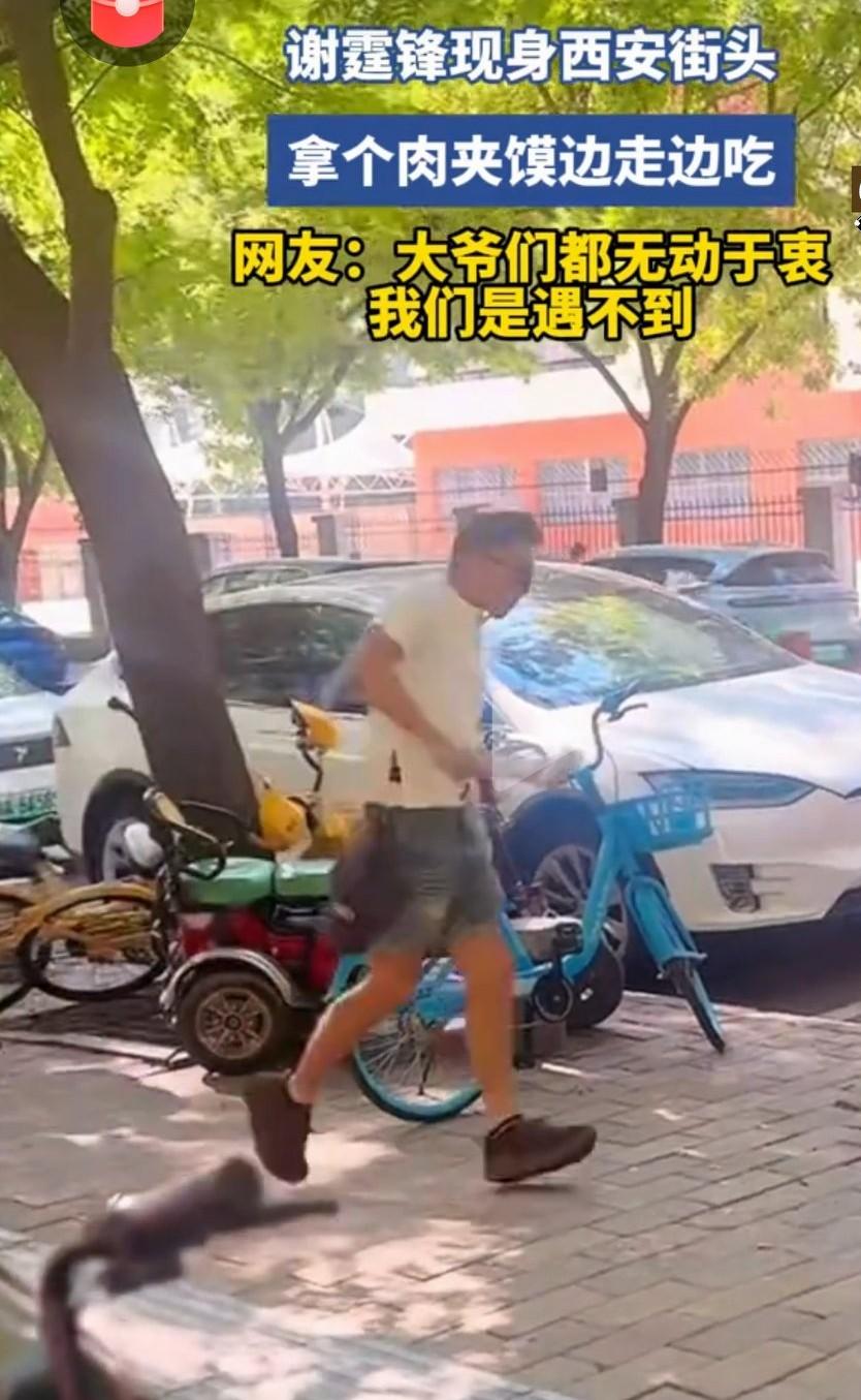 谢霆锋拿个肉夹馍在街头边走边吃日前，为筹备西安个人演唱会，谢