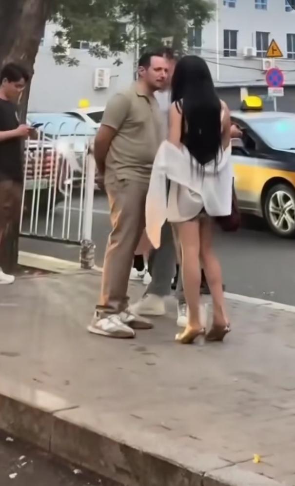 一衣着清凉的女子，街上遇见两个洋人，上前搭讪。没想到遭洋人怒斥。女子自讨没趣
