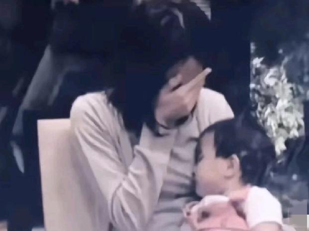 候机室里，王菲掩面哭泣，怀里熟睡的窦靖童才一岁多。这是她收到母亲去世的消息后