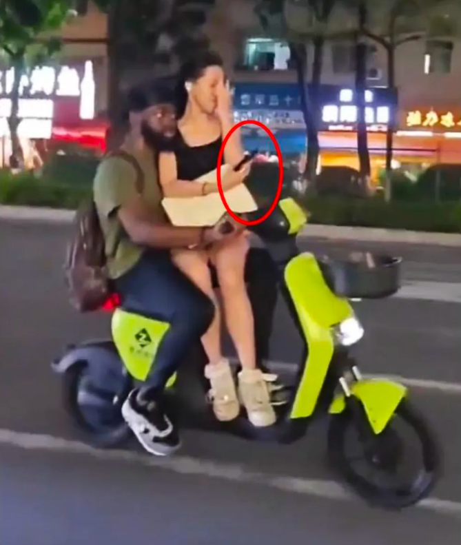 这得有多惬意！怀抱美女，手握单车方向把，黑白分明。来中国的初衷就是这个了吧？做为