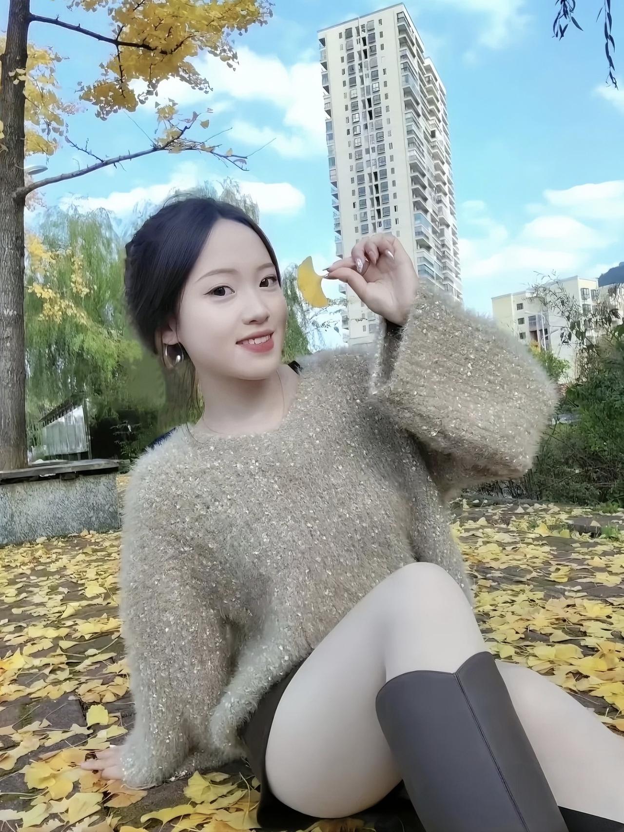 秋意浓时，银杏叶把大地铺成了金色的海～坐在满是落叶的地面上，捏着一片金黄的银杏叶